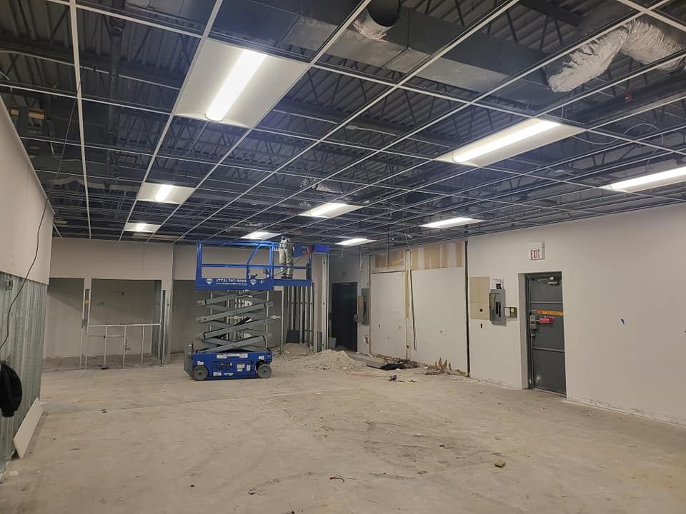 There is a scissor lift in the middle of the room.