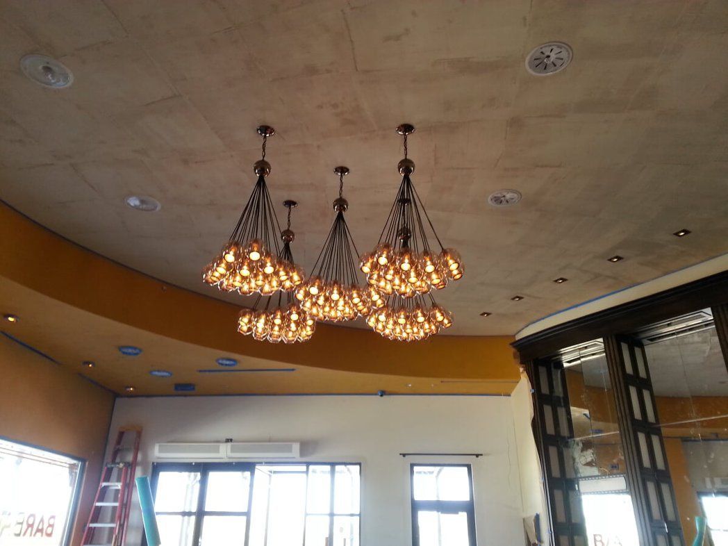 A room with a lot of chandeliers hanging from the ceiling