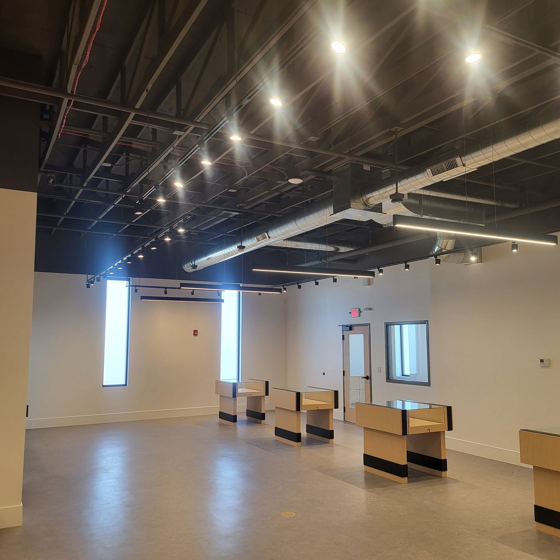 A large empty room with a lot of lights on the ceiling