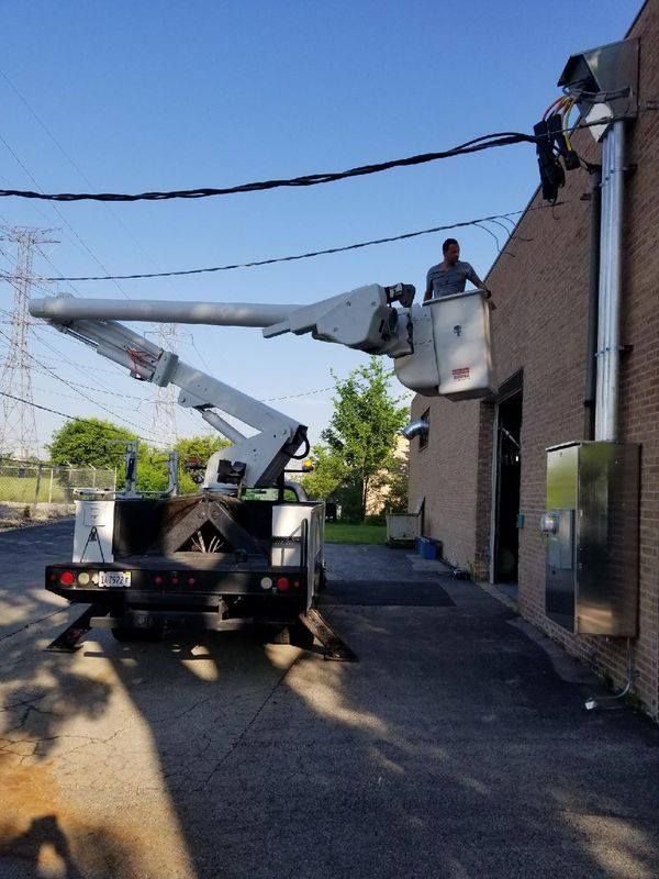 A man in a bucket truck is working on a building