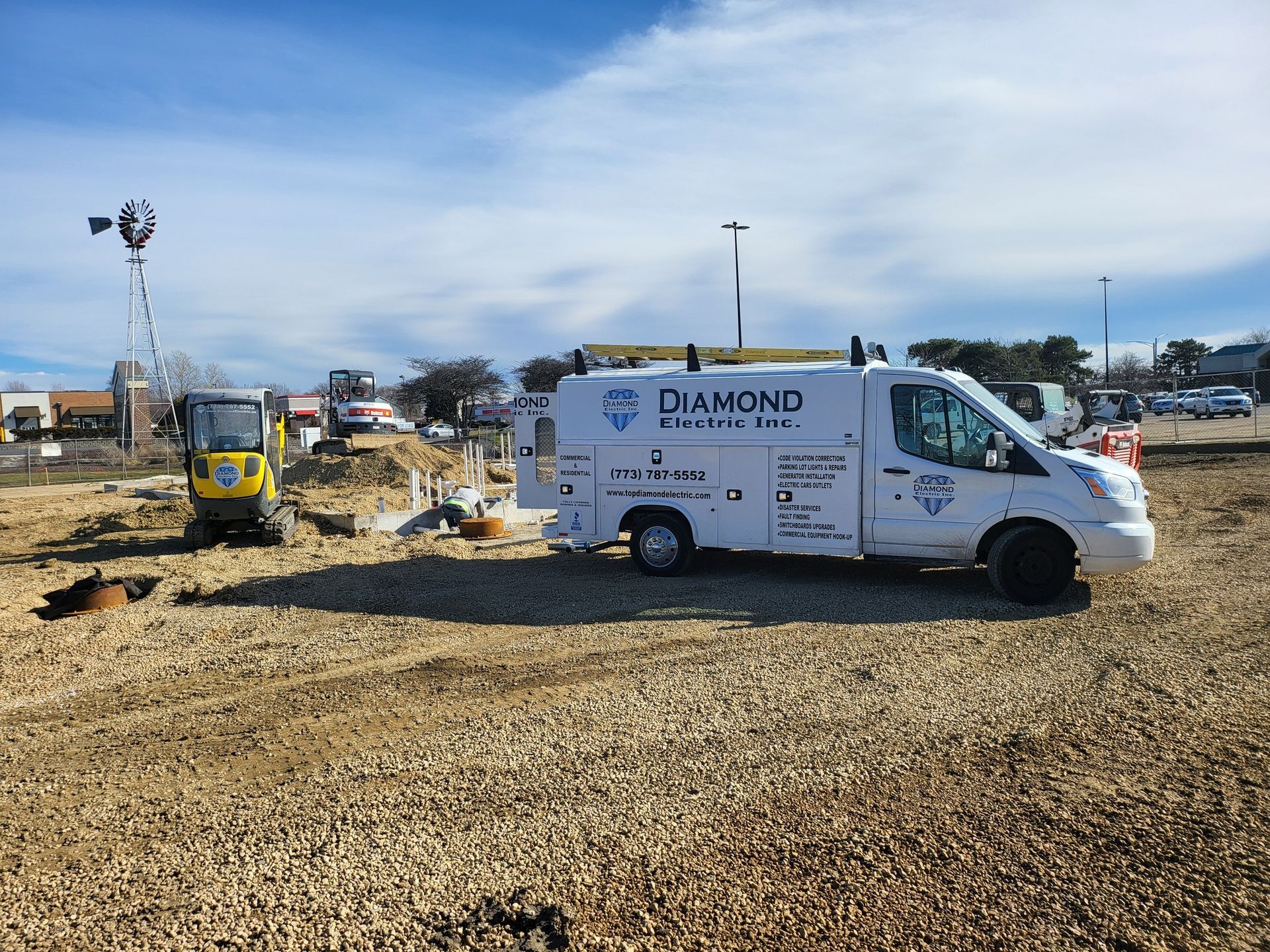 A diamond van is parked in a gravel lot.