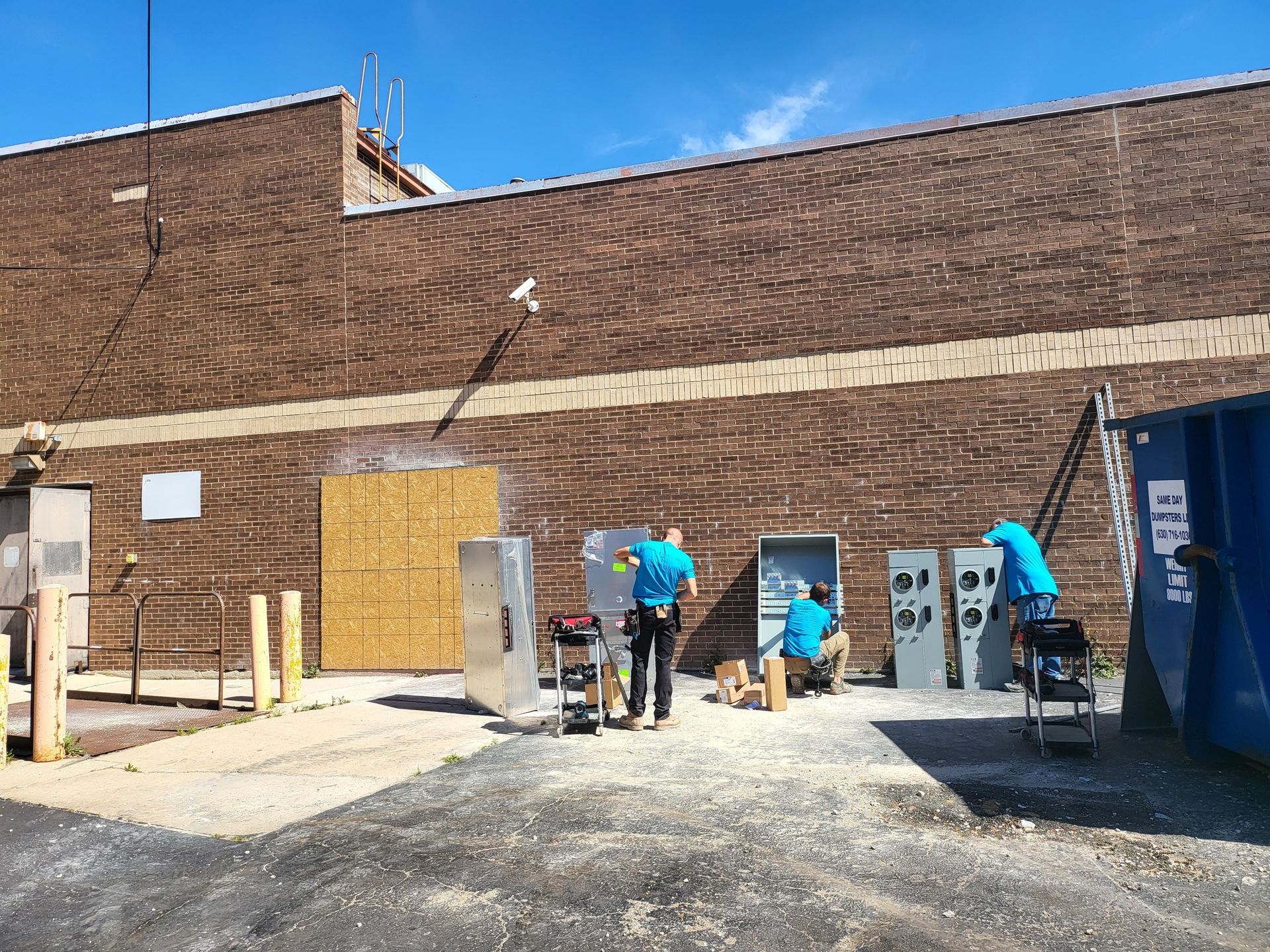 A group of men are standing in front of a brick building.