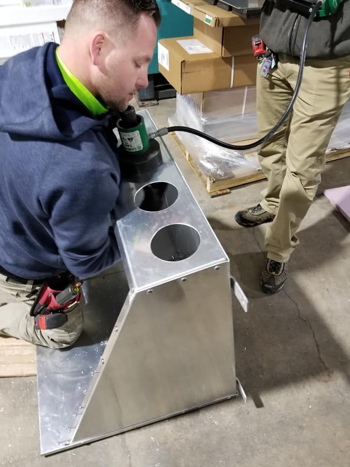 A man is working on a piece of metal in a factory.