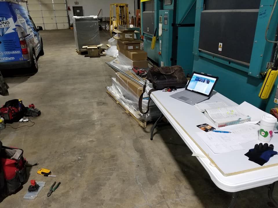 A laptop is sitting on a table in a warehouse.