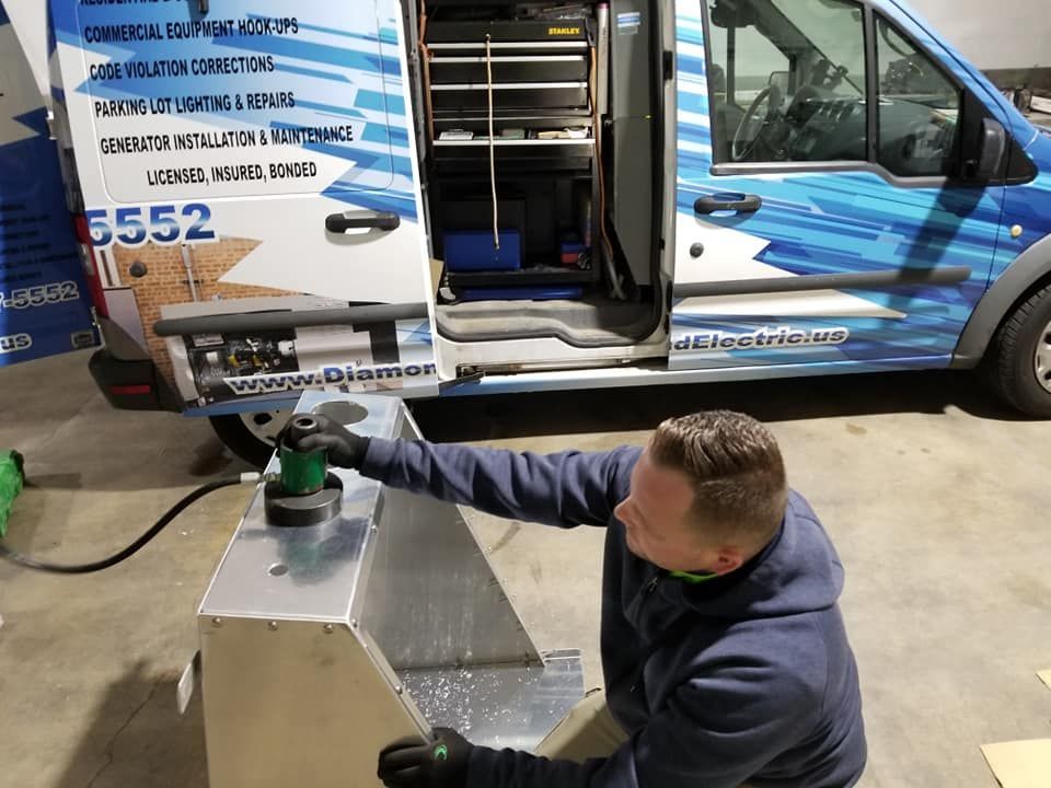 A man is working on a piece of metal in front of a van.