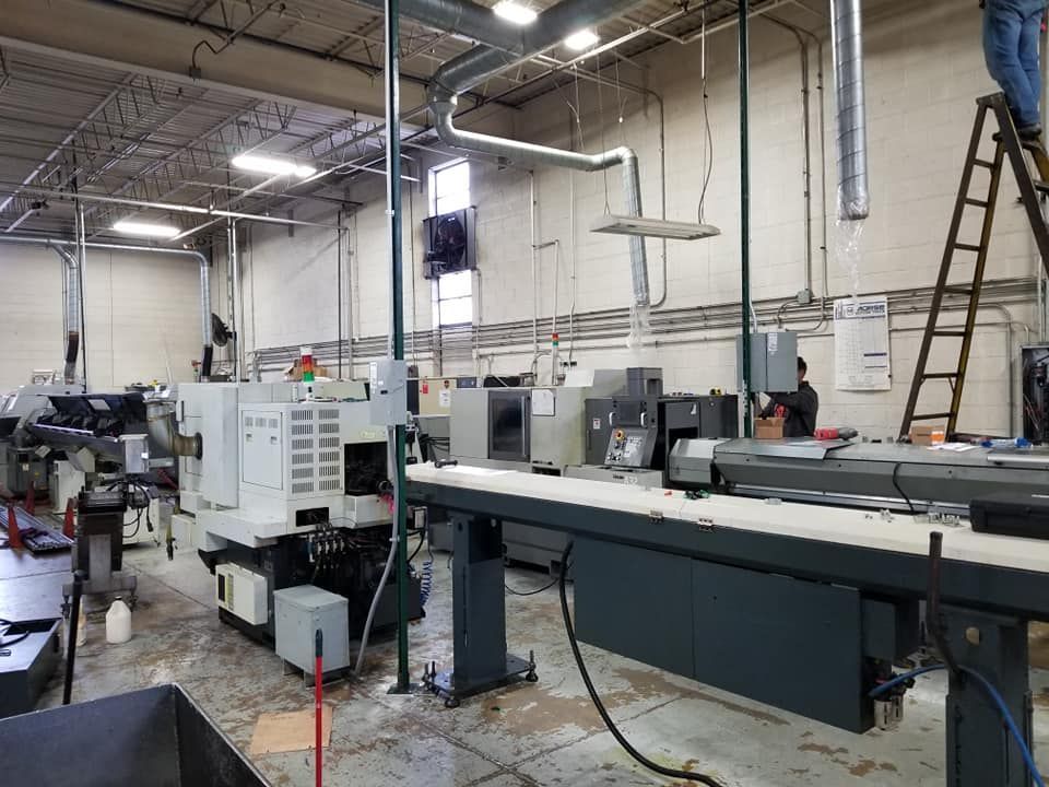 A man is standing on a ladder in a factory.