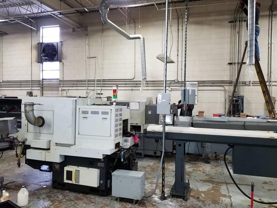 A machine is sitting in the middle of a room in a factory.