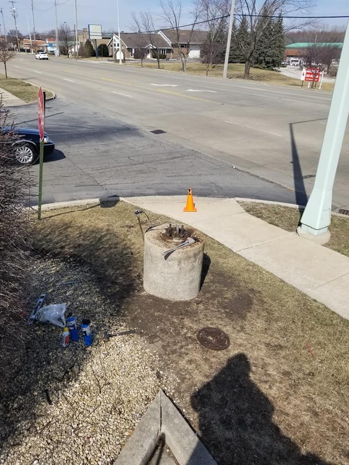 A concrete block is sitting on the side of the road next to a sidewalk.