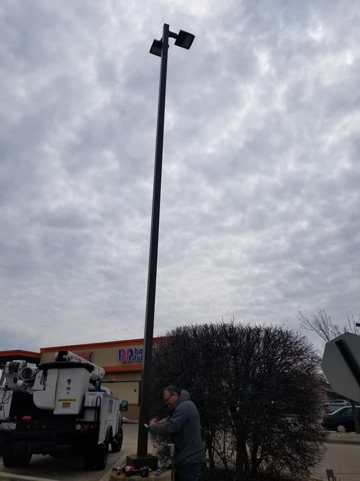 A man is working on a street light outside of a store