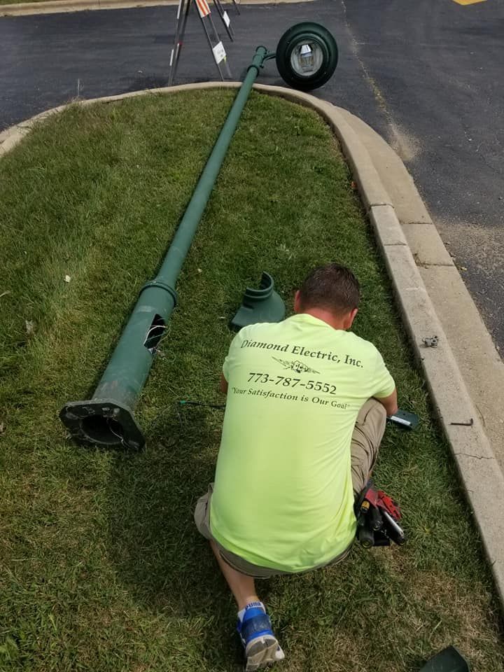 A man in a neon green shirt is working on a street light.