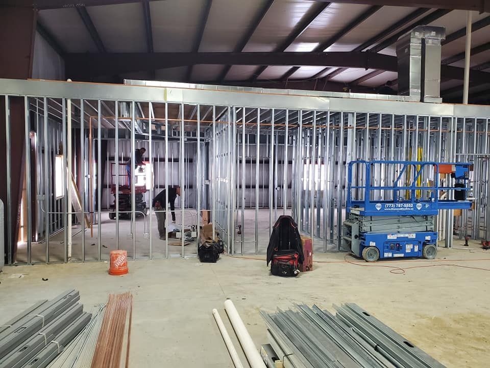 A large room with a lot of metal walls and a lift in the middle of the room.