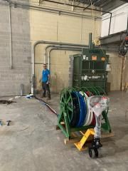 A man is standing next to a machine in a warehouse.