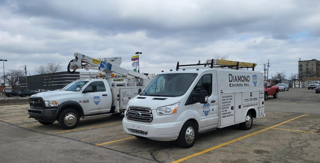 Two white vans are parked next to each other in a parking lot.