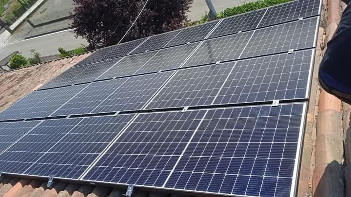 Pannelli solari installati su un tetto di tegole rosse, che assorbono la luce solare.