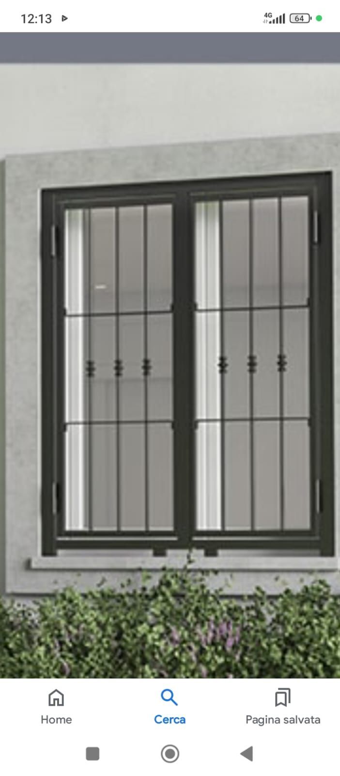 Finestra con cornice scura, sbarre verticali e cespugli verdi.