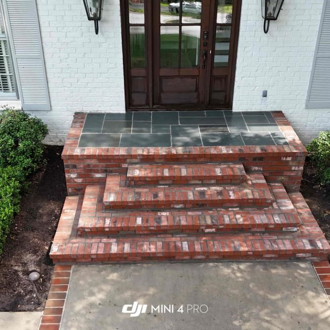 A skilled construction worker carefully placing bricks in a masonry wall using a trowel.