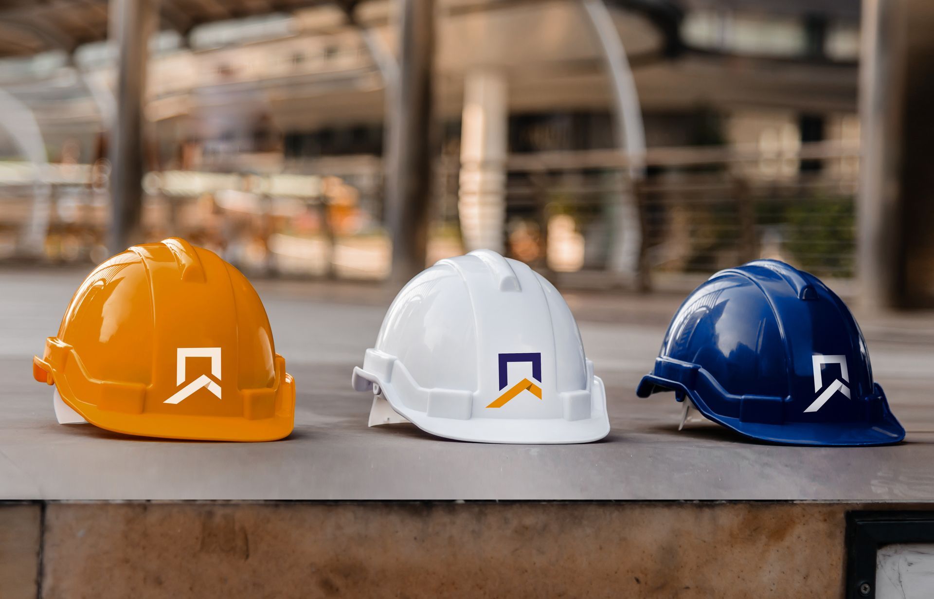 Three hard hats are sitting next to each other on a sidewalk.