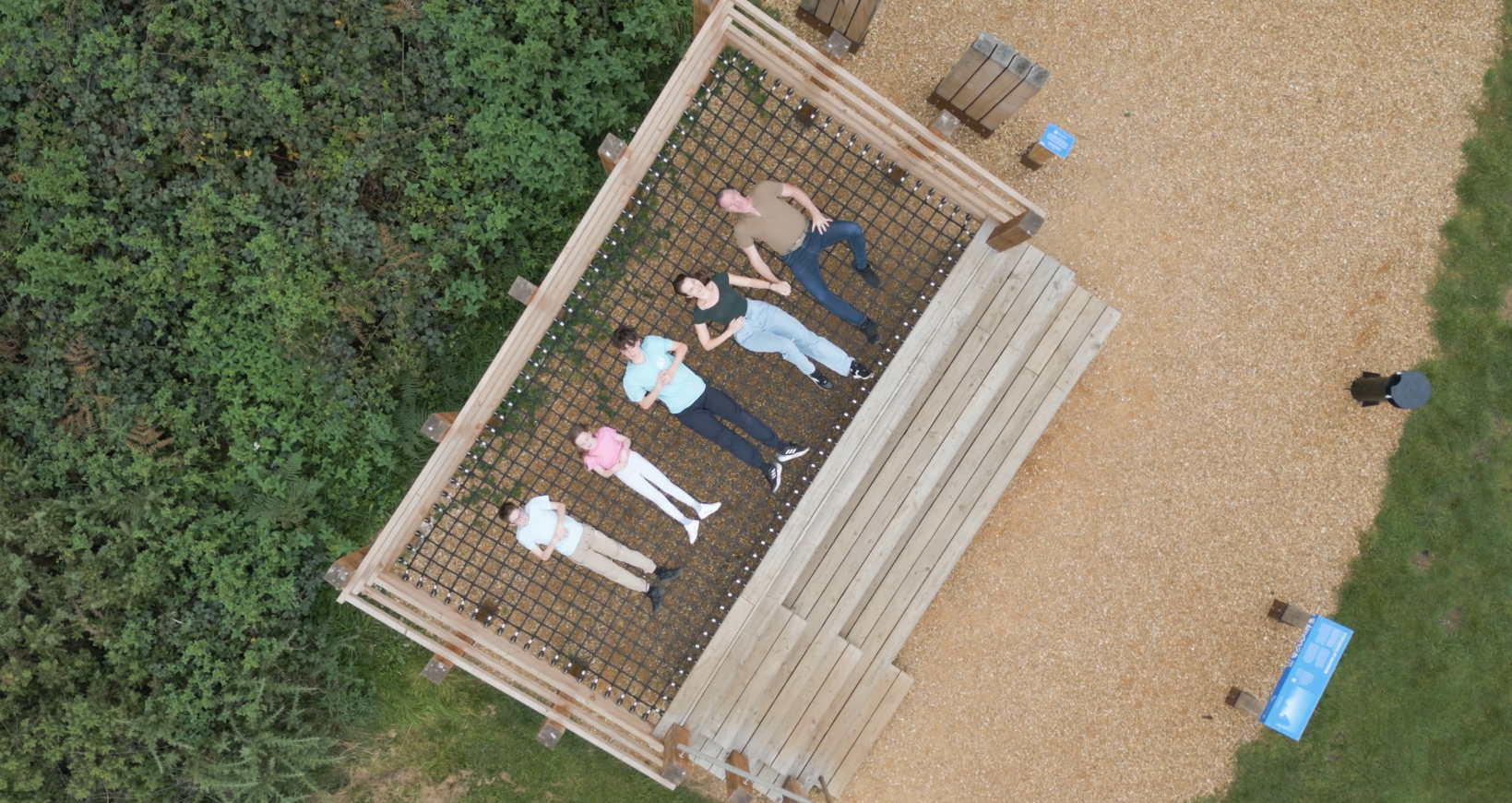 An aerial view of a group of people laying on a wooden platform.