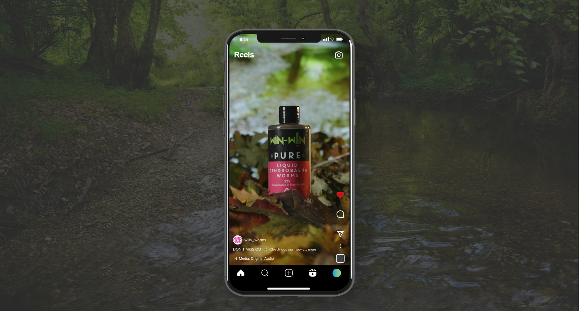A cell phone is displaying a picture of a bottle of perfume in the woods.