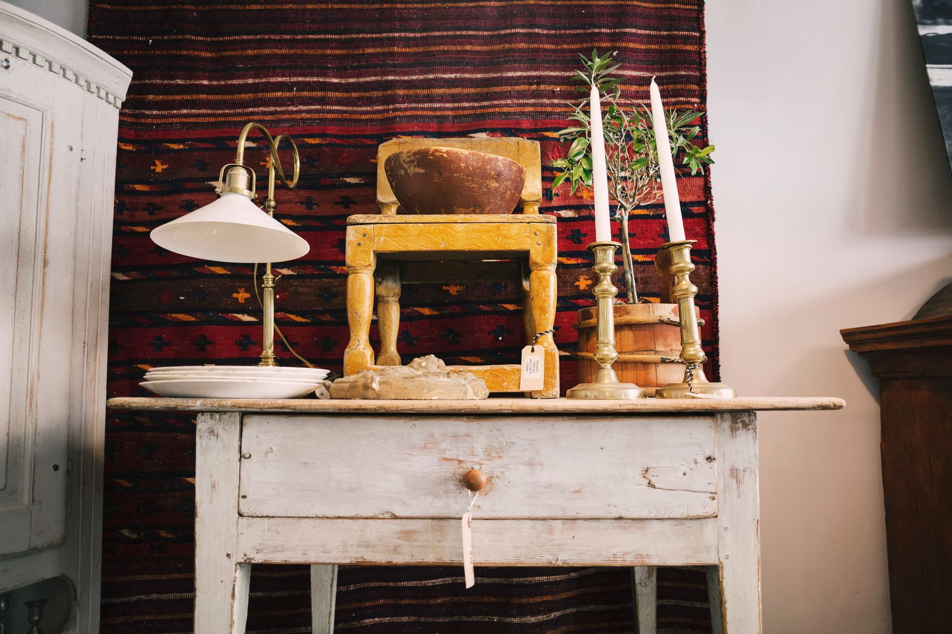 A table with candles and a lamp on it.