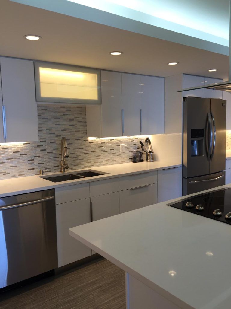 Modern kitchen with white cabinets, stainless steel appliances, and a large island countertop.