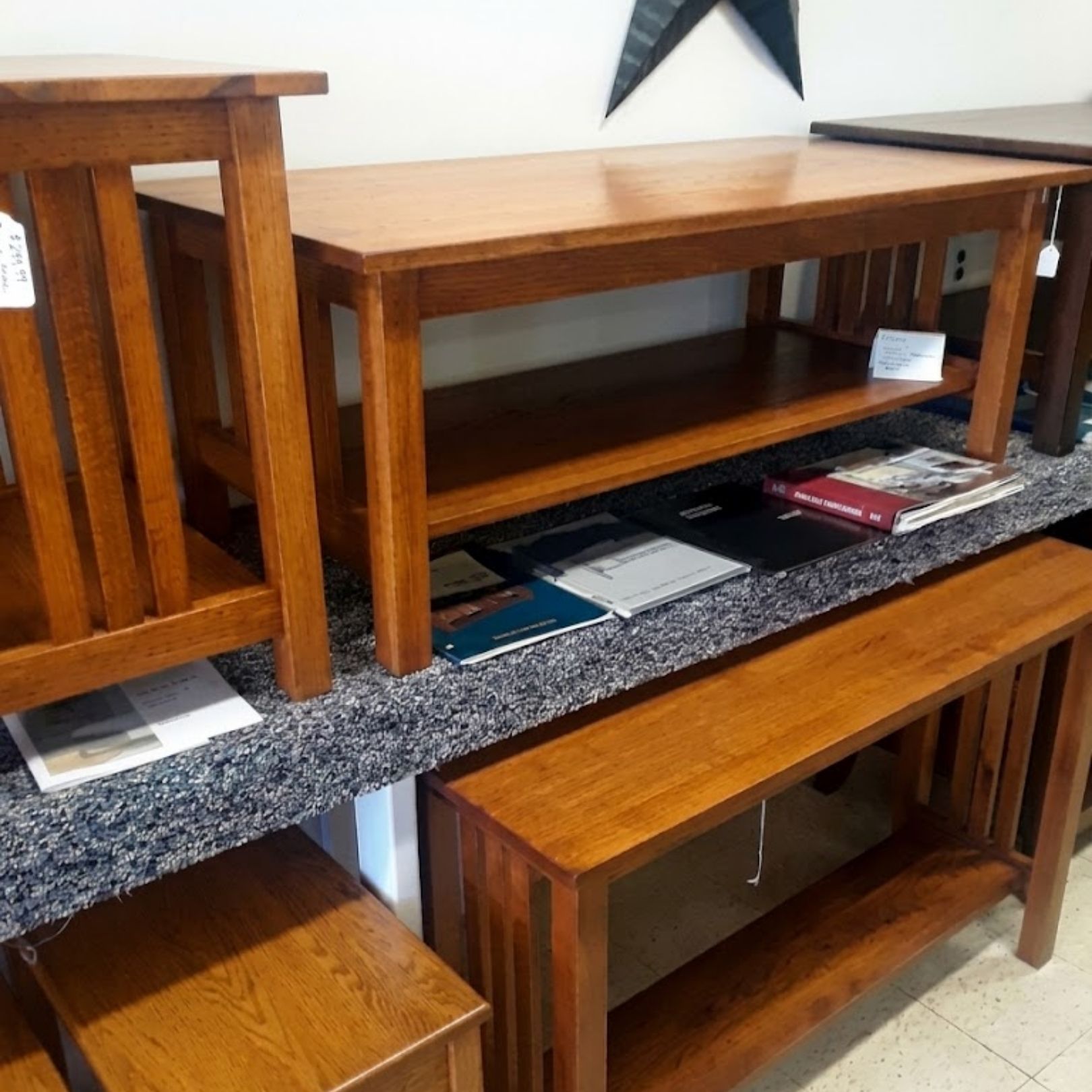 Wooden tables and benches arranged in a room, with magazines and books on shelves.