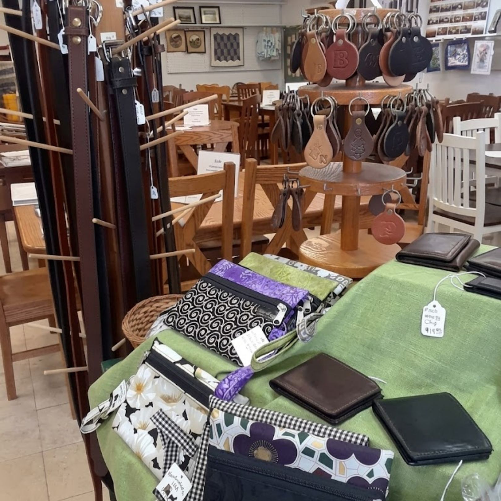 Gift shop display with colorful folded cloths, leather goods, and wooden decor items on shelves and tables