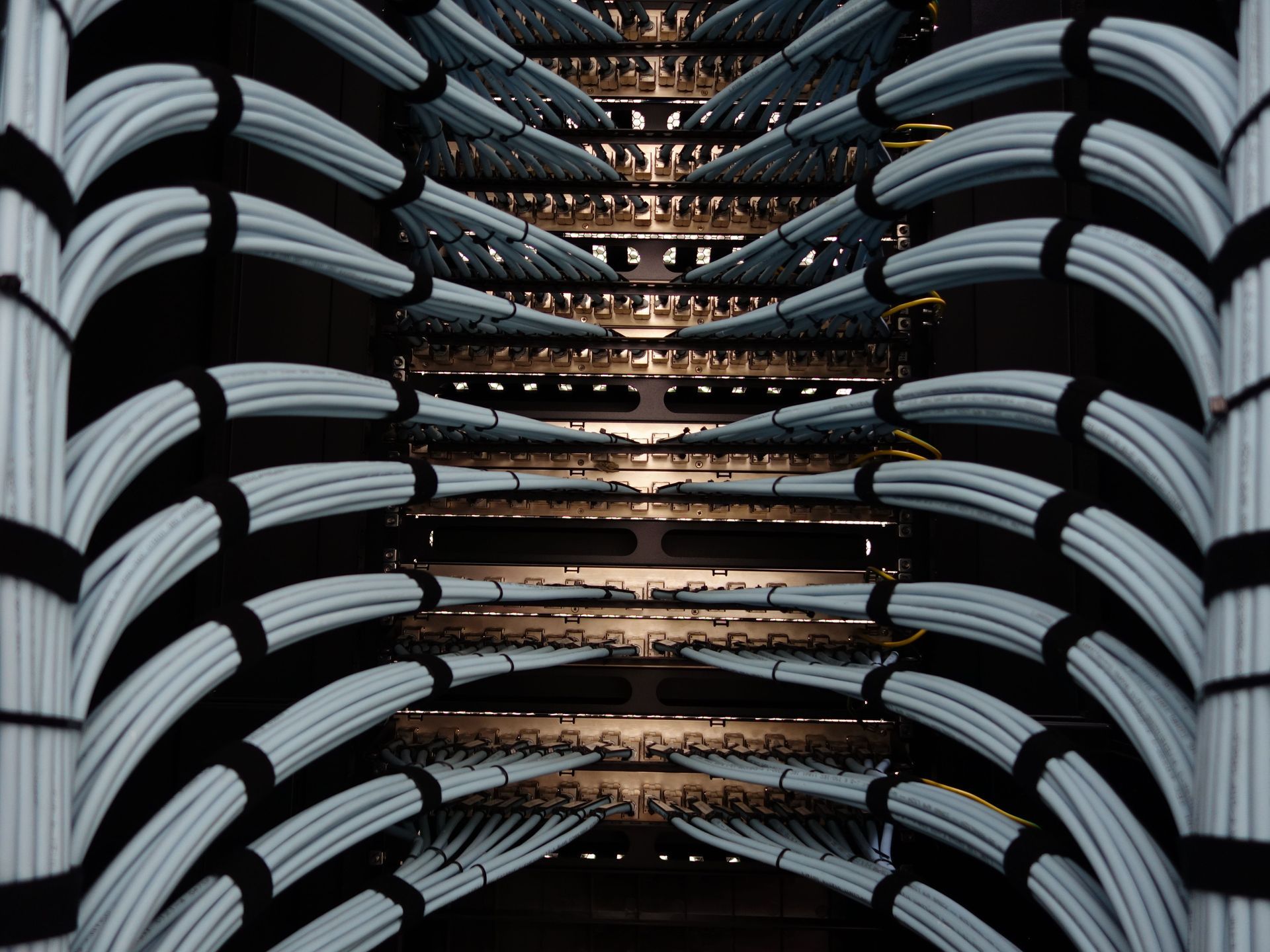 Abstract view of stacked white curved seats around a central staircase with warm lights