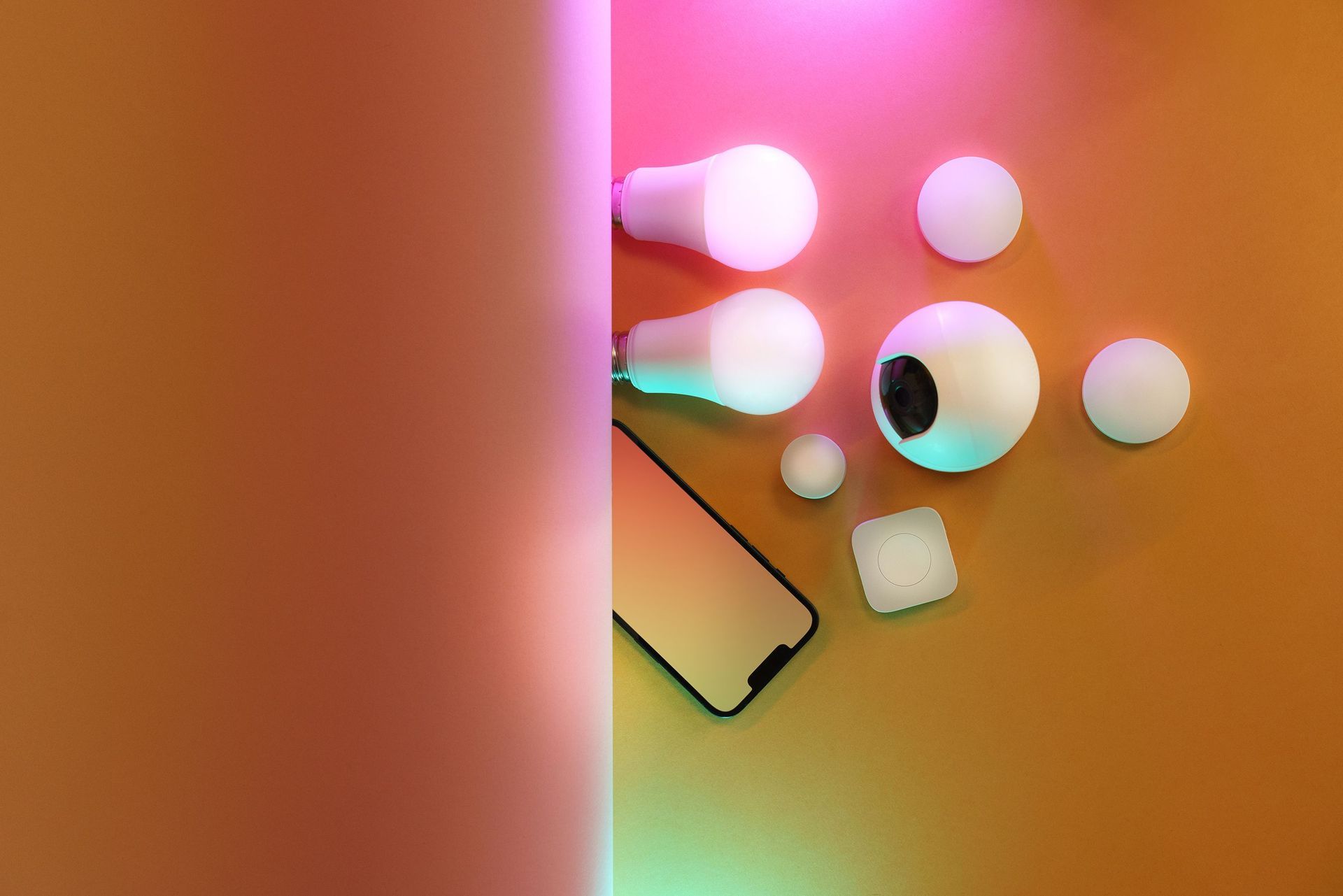 Abstract arrangement of glowing spheres and a phone on a warm orange-pink background