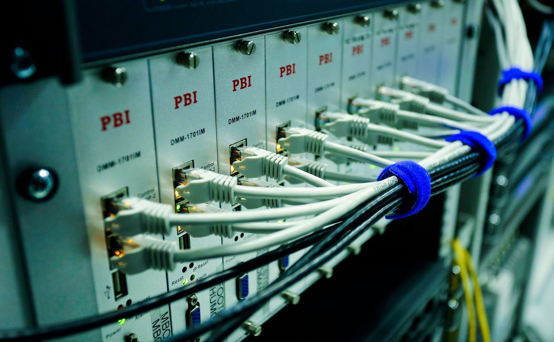 Network server rack with rows of PBI modules and bundled white and blue cables connected to ports