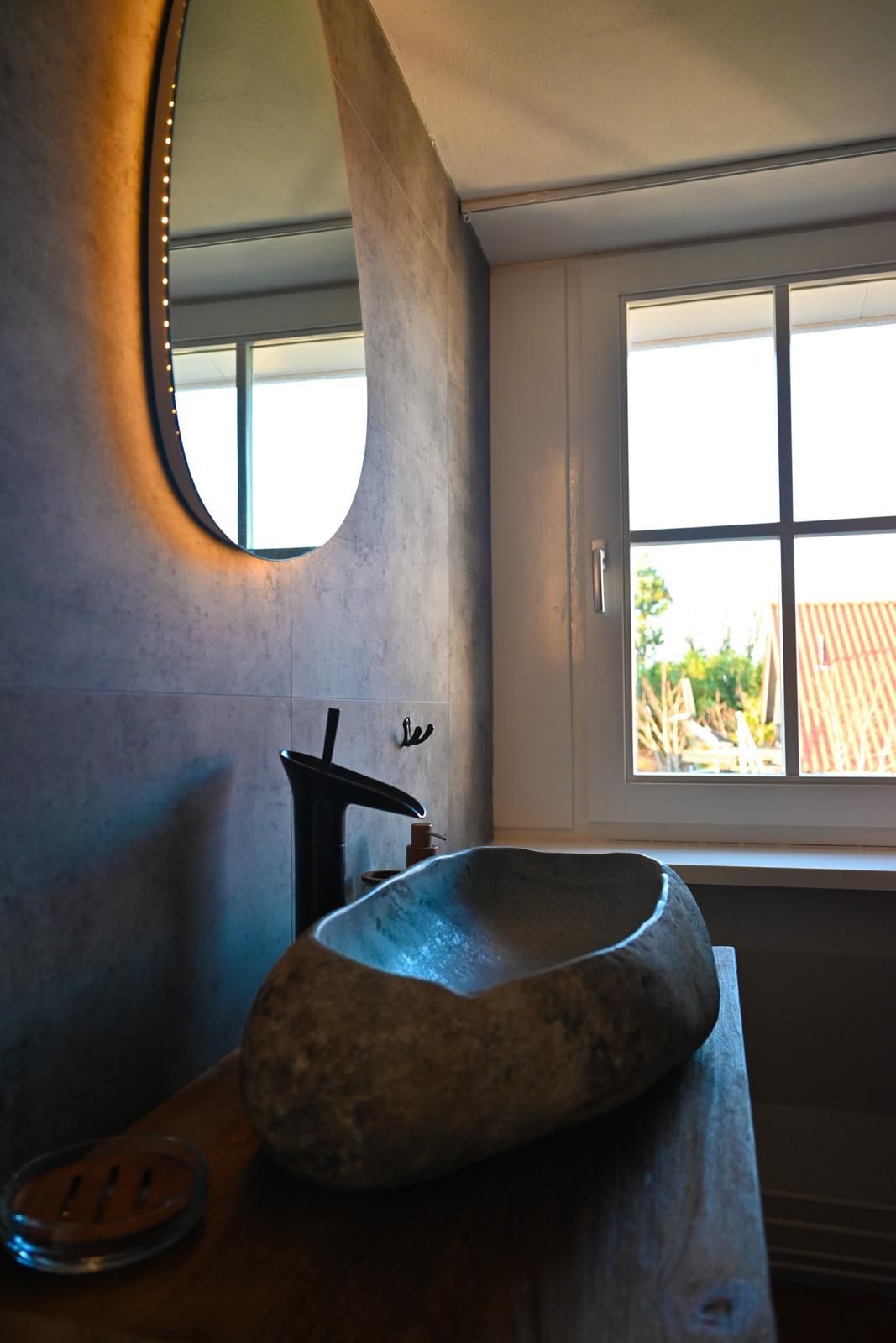 De overloop met spiegel en wastafel van Vakantiehuis Akkerzicht Oudesluis.