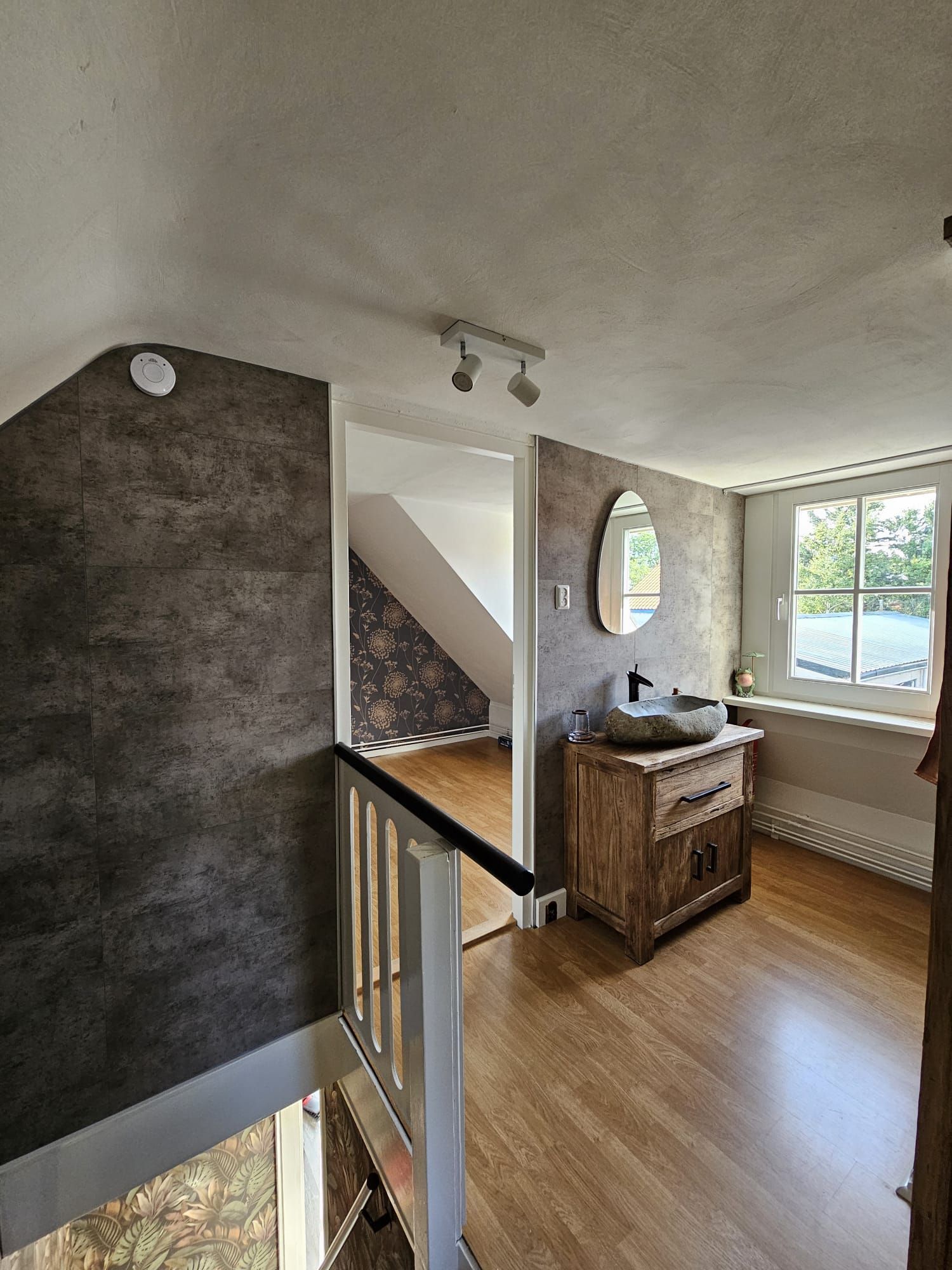 De overloop met spiegel en wastafel van Vakantiehuis Akkerzicht Oudesluis.