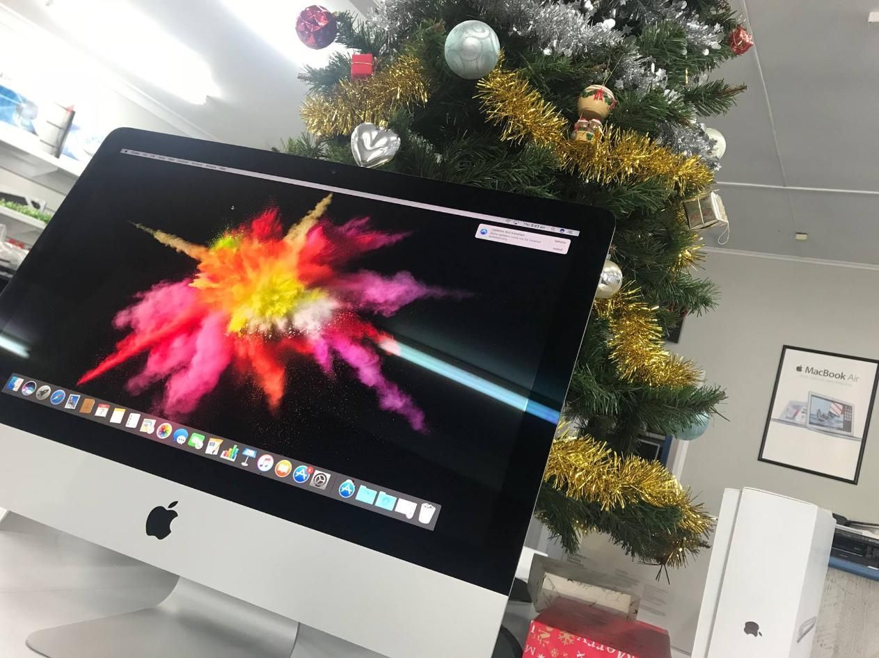 An Apple Computer is Sitting in Front of a Christmas Tree — Coastal Computing Solutions in Old Bar, NSW