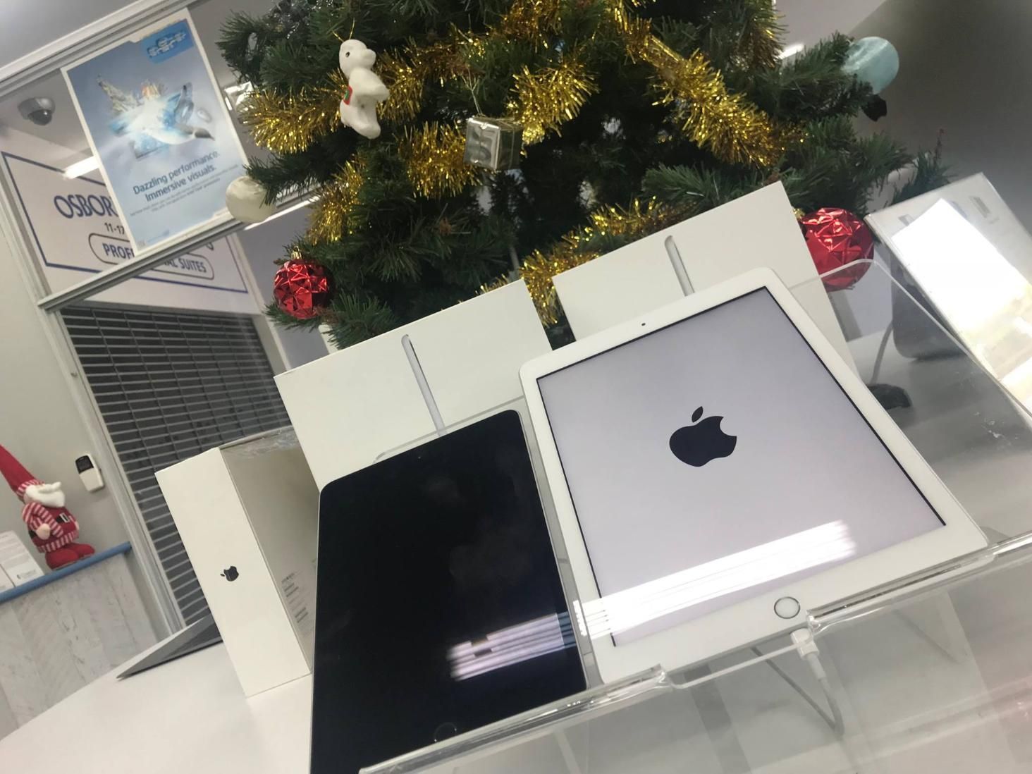 Two Apple Ipads Are Sitting on a Table in Front of a Christmas Tree — Coastal Computing Solutions in Forster, NSW