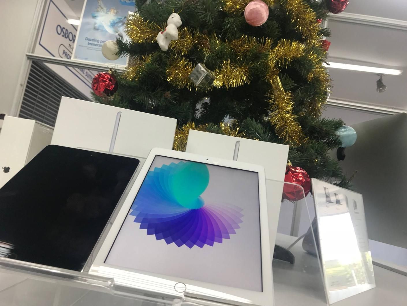 Two Ipads Are Sitting in Front of a Christmas Tree — Coastal Computing Solutions in Forster, NSW