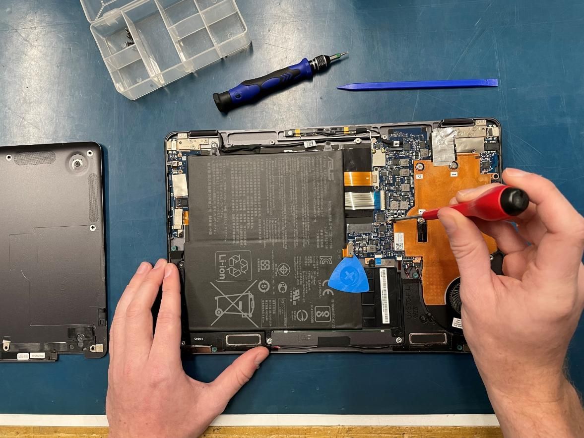 A Person is Fixing a Tablet With a Screwdriver — Coastal Computing Solutions in Tuncurry, NSW