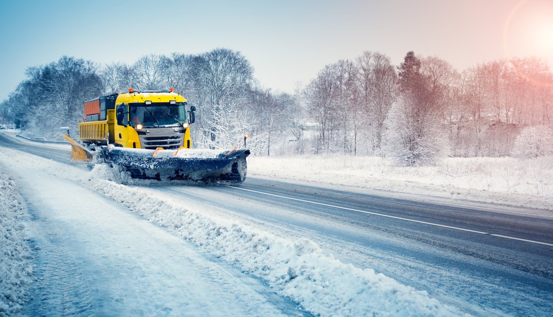Un chasse-neige déblaye la neige de la route.