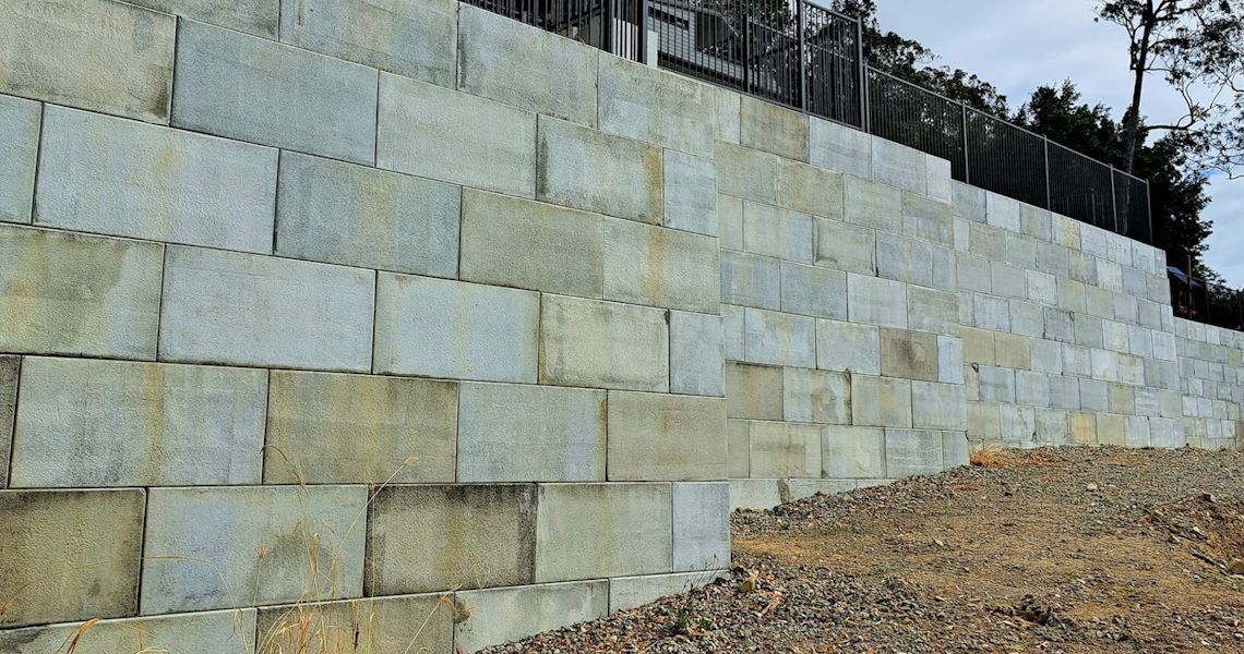Large Brick Wall Is Sitting on Top of A Dirt Hill — Green Envy Landscapes Pty Ltd In Carrara, QLD