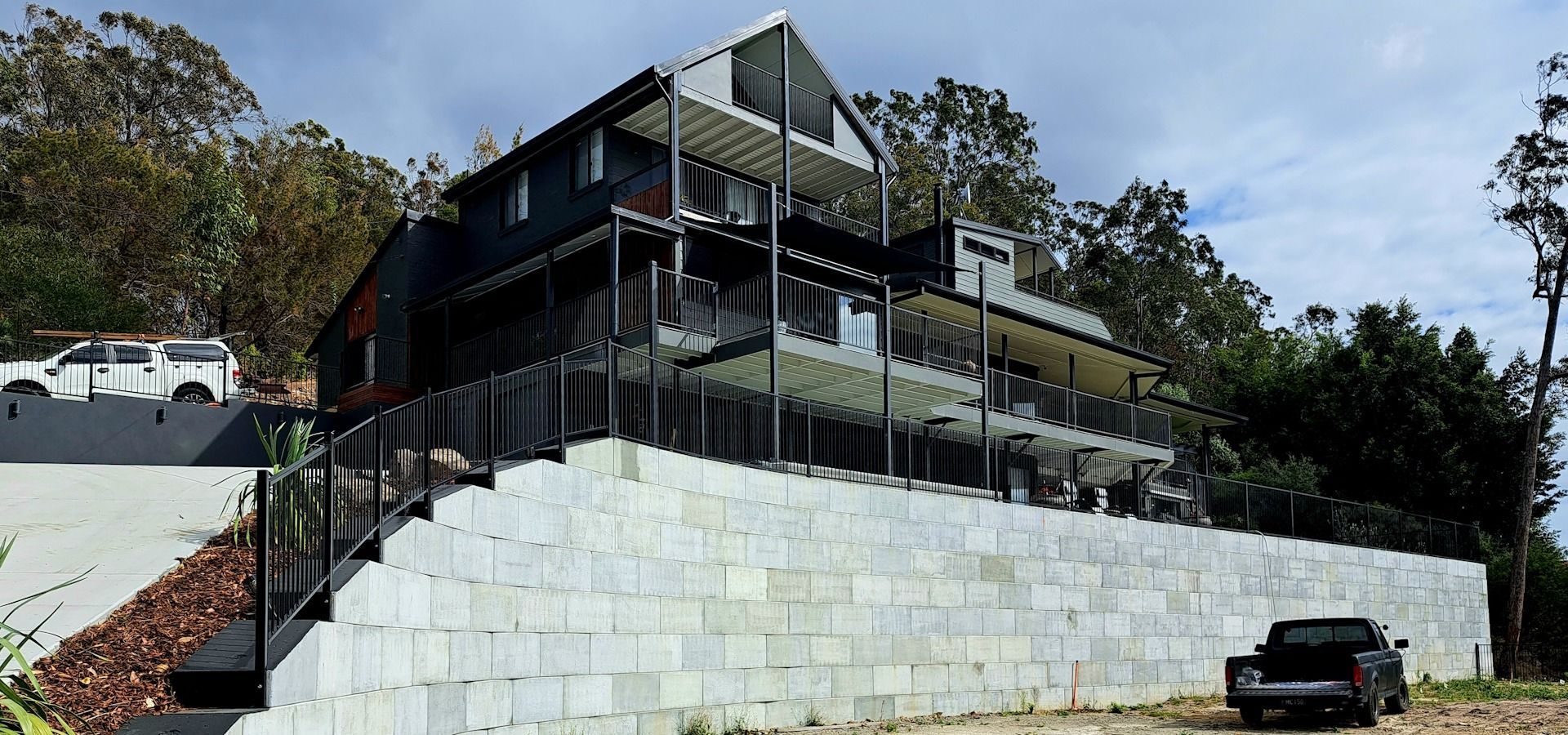 A Large House Is Sitting On Top Of A Hill — Green Envy Landscapes Pty Ltd In Carrara, QLD