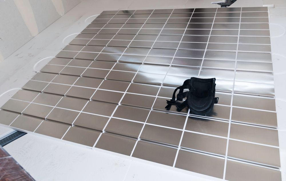 Underfloor heating installation in a room, with pipes laid across a reflective sheet on the floor, and pipes on the walls.