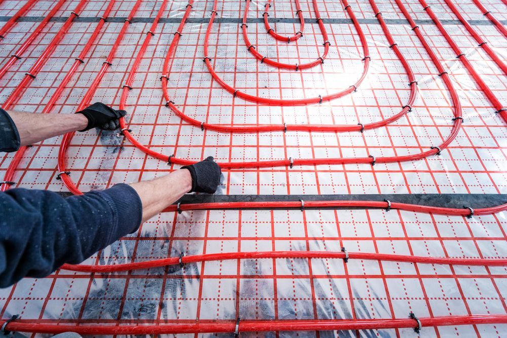 Hands Installing Radiant Floor Heating System — Illawarra Underfloor Heating In Wollongong, NSW