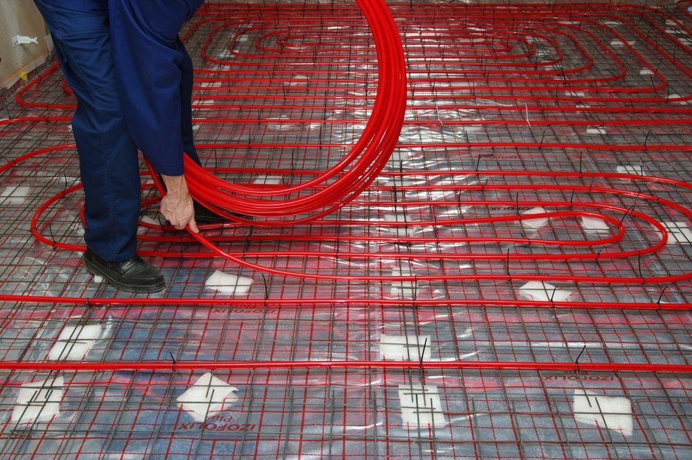 Person Installing Red Radiant Floor Heating  — Illawarra Underfloor Heating In Ulladulla, NSW