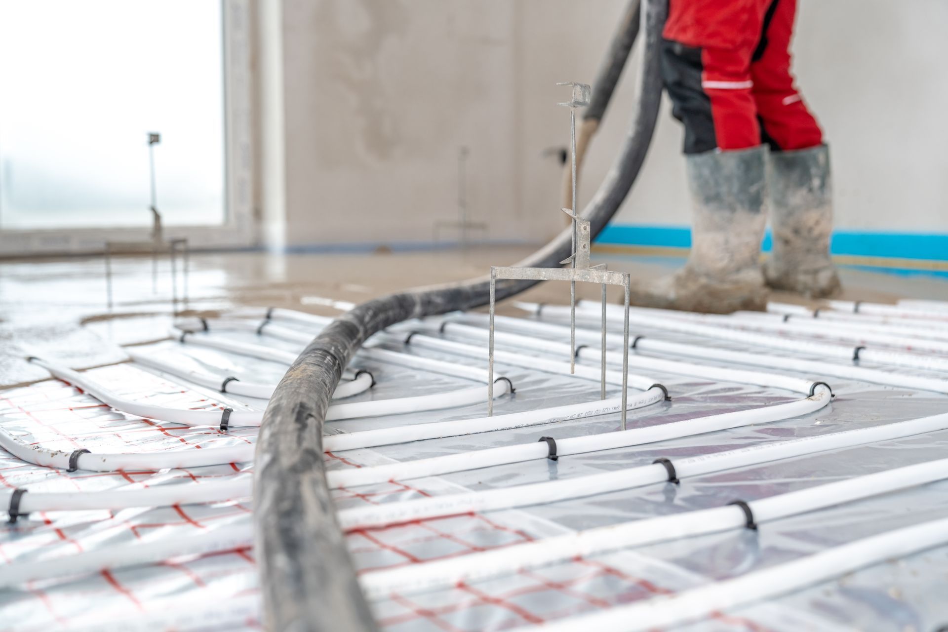 Person Pouring Concrete Floor Over Radiant Heating Tubes — Illawarra Underfloor Heating In Bellambi, NSW