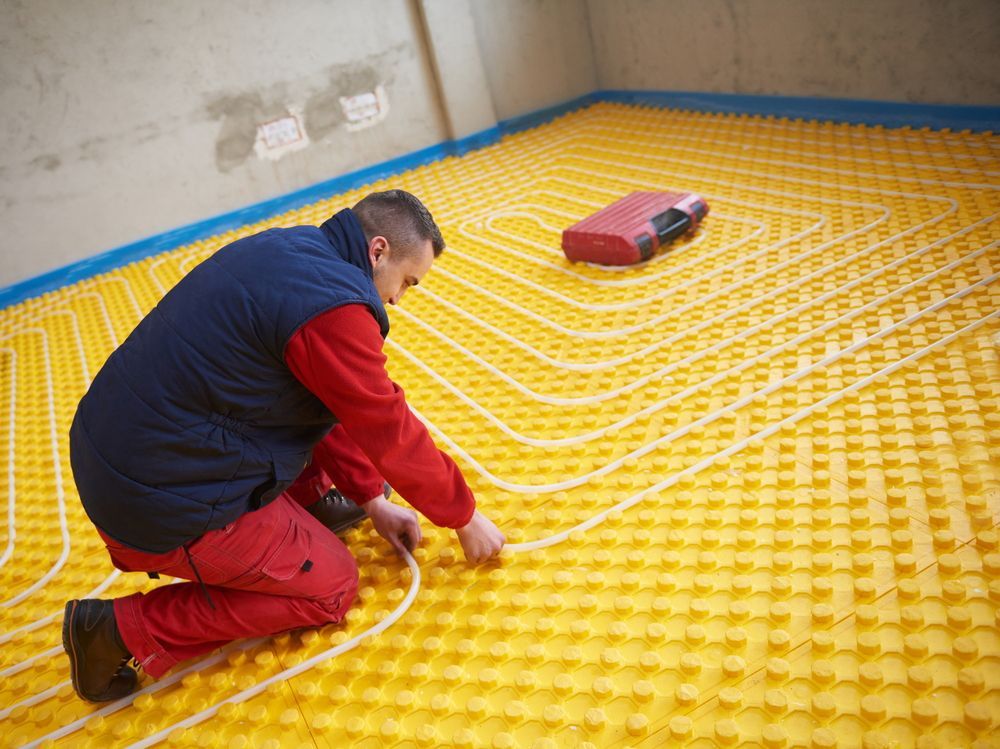 Man Installing Radiant Floor Heating System — Illawarra Underfloor Heating In Southern Highlands, NSW