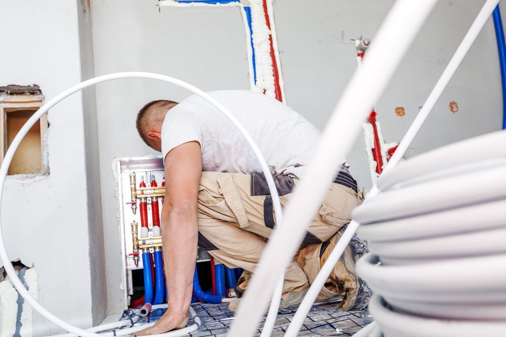 Plumber  Inspecting Pipes Inside a Wall — Illawarra Underfloor Heating In Wollongong, NSW