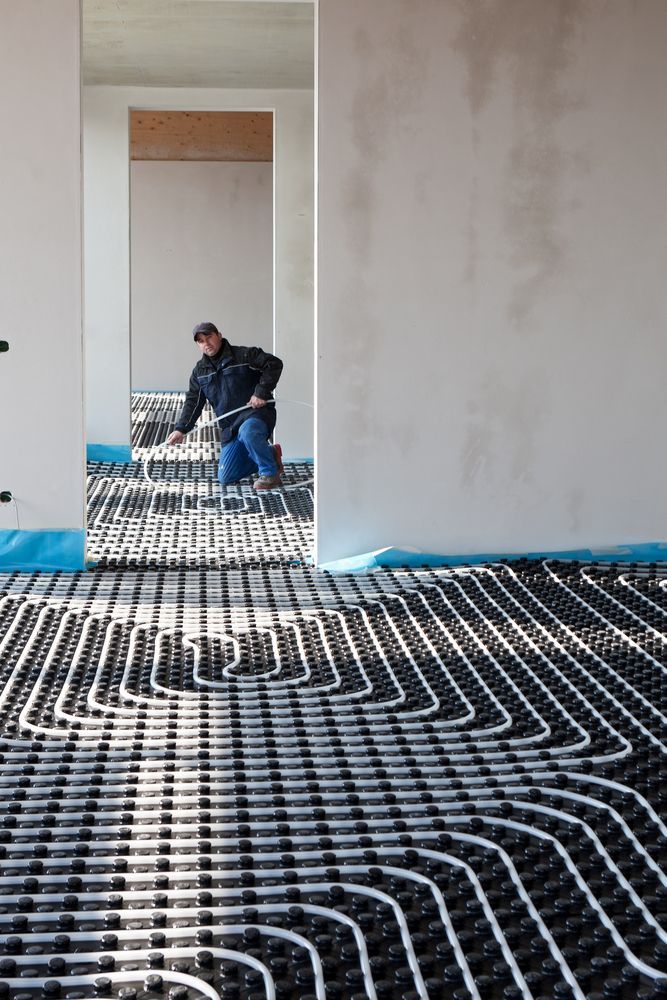 Worker Installing Radiant Floor Heating System in A Room — Illawarra Underfloor Heating In Wollongong, NSW
