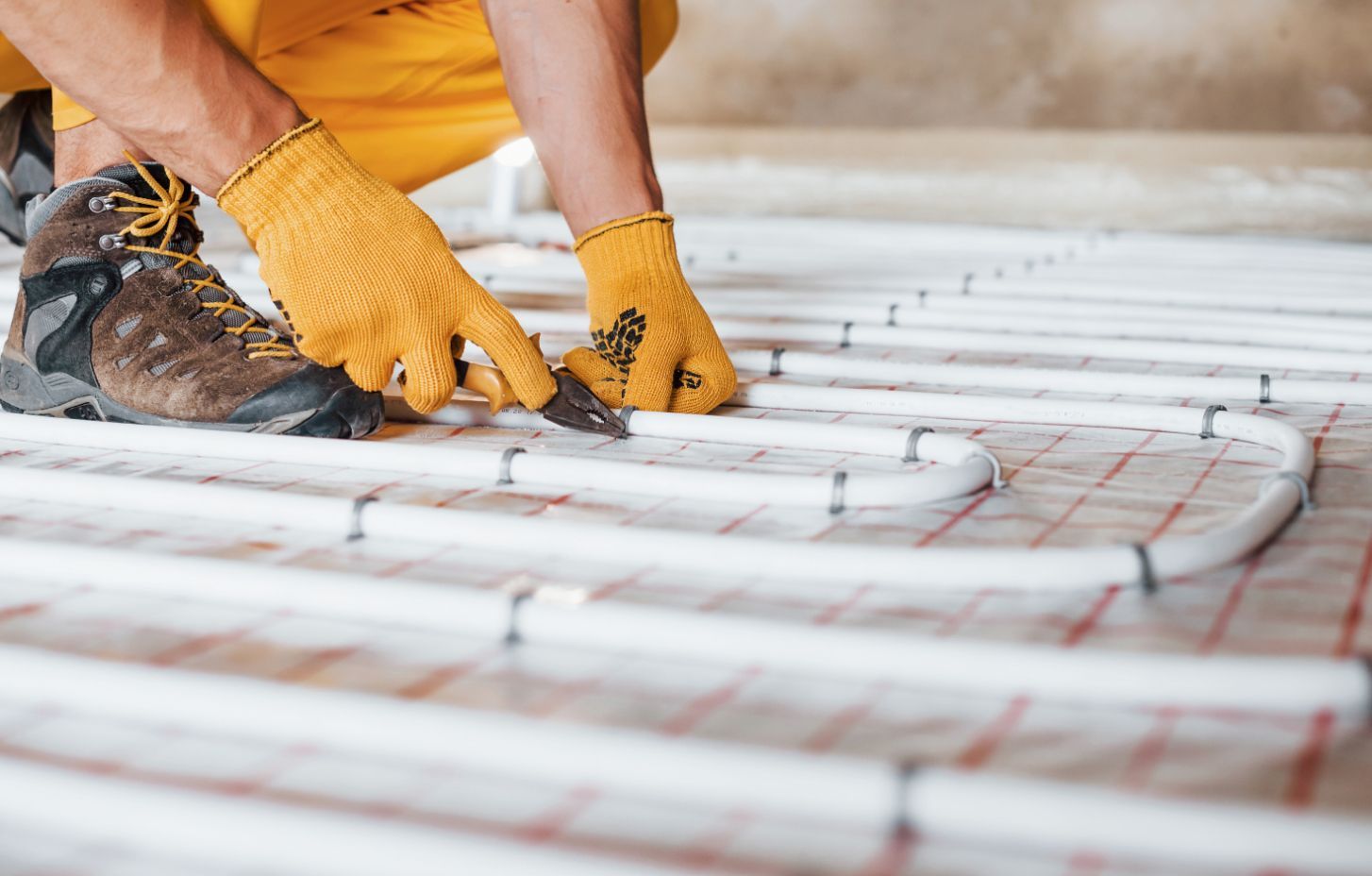 Person Installing Radiant Floor Heating, Wearing Gloves — Illawarra Underfloor Heating In Nowra, NSW
