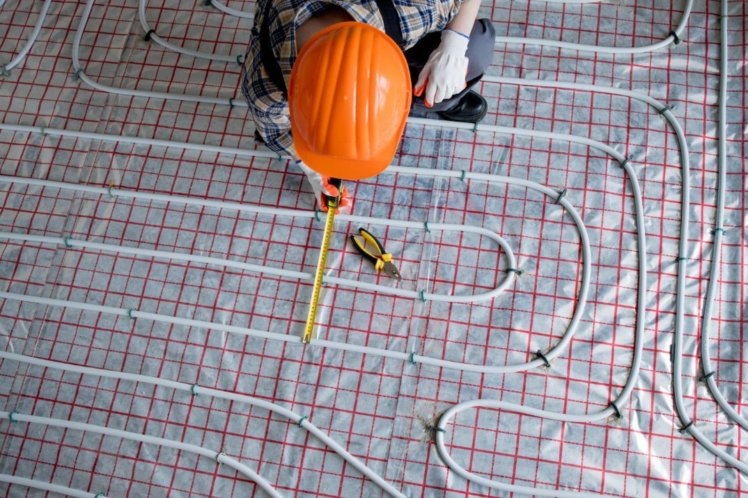 Person Wearing a Hat Installing Underfloor Heating System — Illawarra Underfloor Heating In Southern Highlands, NSW