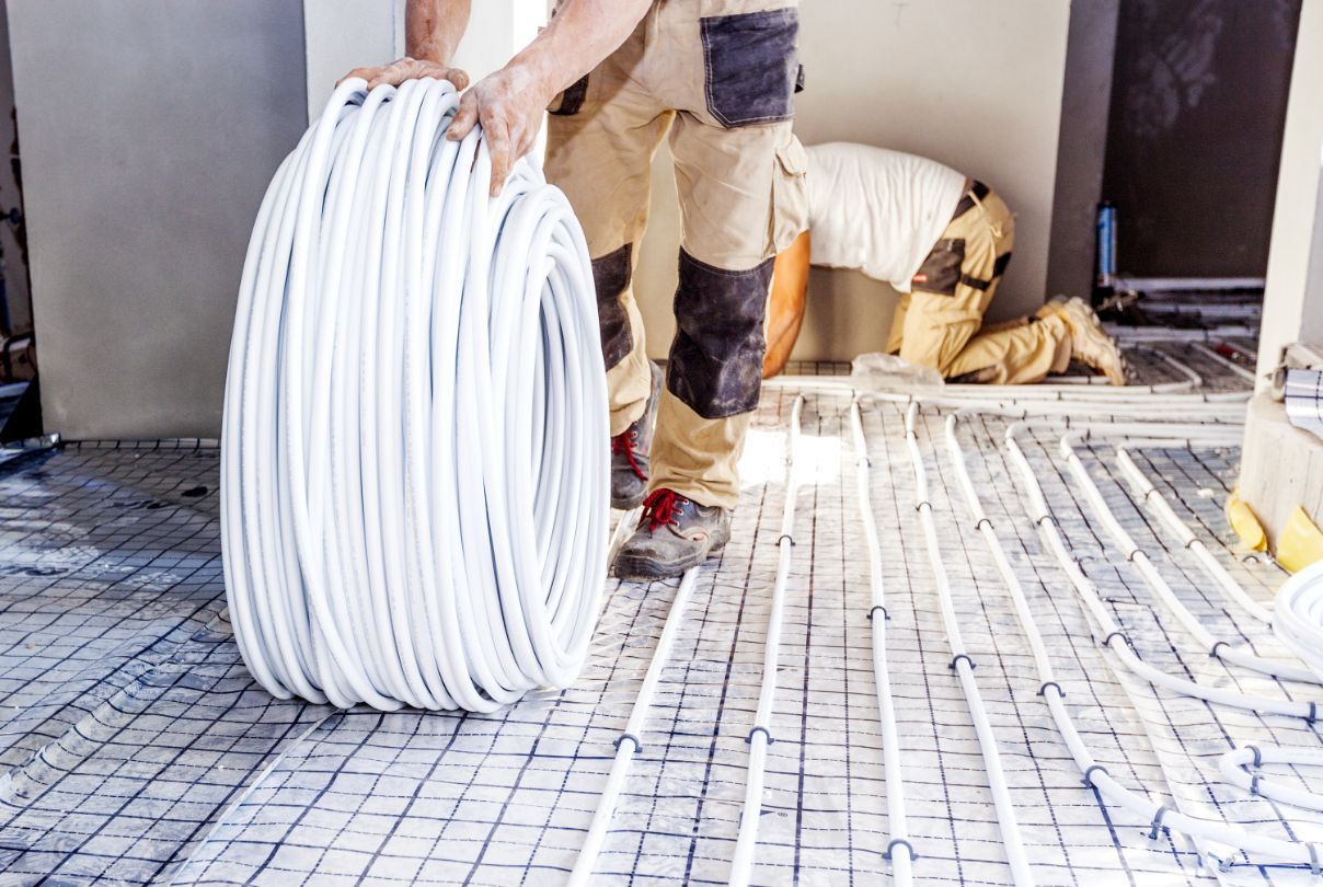 Man Installing Radiant Floor Heating Tubes on A Grid — Illawarra Underfloor Heating In Ulladulla, NSW