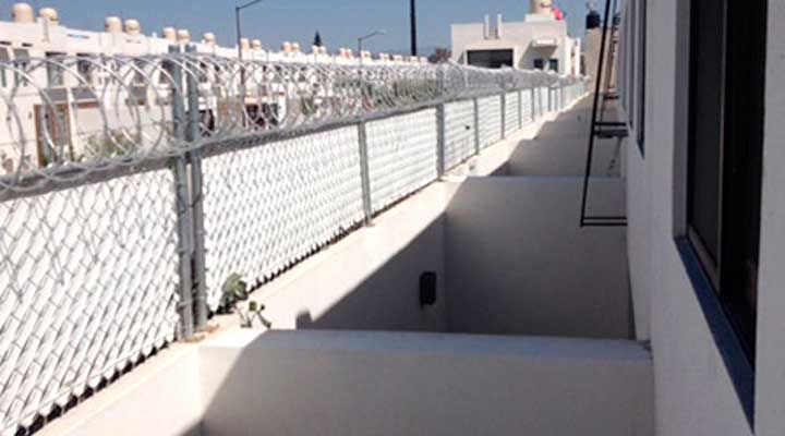 Un balcón con una valla metálica y una ventana